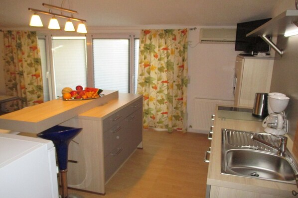 A compact kitchen with a central island, a built-in sink, and a microwave. - Double Room with Balcony 1 (Omis)