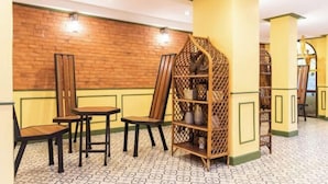 A room with a brick wall, wooden chairs, a wooden bookshelf, and patterned floor tiles. - 75 Paradise Lane Managed by Loft Group (Bangkok)