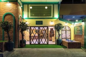 A hotel entrance with a sign reading "Paradise Lane," featuring a brick facade, green arches, and potted plants. - 75 Paradise Lane Managed by Loft Group (Bangkok)