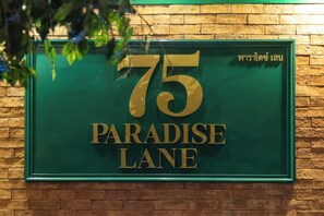 A green sign with the number 75 and the words "Paradise Lane" in gold lettering. - 75 Paradise Lane Managed by Loft Group (Bangkok)