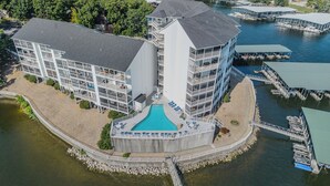Ein modernes Hotel mit zentralem Schwimmbad, mehreren Balkonen und einer Lage am Wasser.