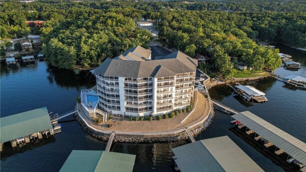 Ein Hotel am Wasser mit einem runden Gebäude, mehreren Balkonen und einem Steg.