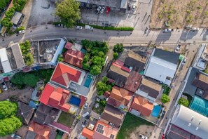 An aerial view of a residential area with houses, roads, and greenery. - T M L-Urban 4 Bedroom-Independent Swimming Pool and Ktv (Pattaya)