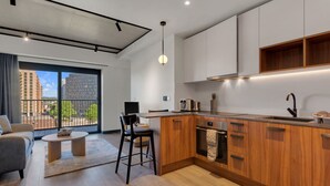 Una cucina moderna con mobili in legno, forno a incasso e un'ampia finestra con vista sulla città.