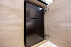 Eine Küche mit einem schwarzen Kühlschrank und Holzschränken.