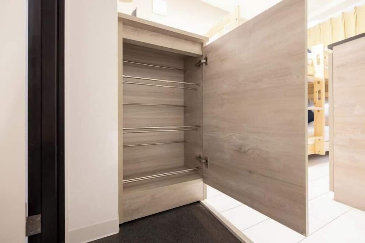 A room with a sliding door, a wooden floor, and a white wall.