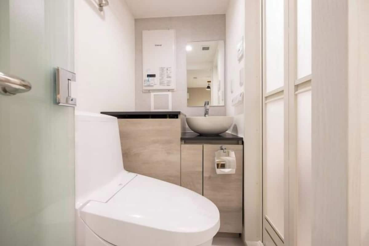 A modern bathroom with a toilet, sink, and cabinet.