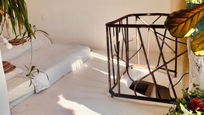 A minimalist room with a bed, a metal-framed table, and various plants. - A P'tit Bali in the Cévennes, with Jacuzzi and breathtaking views! (le martinet)