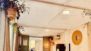 A spacious room with a high ceiling, a fireplace, and a rustic wooden door. - A P'tit Bali in the Cévennes, with Jacuzzi and breathtaking views! (le martinet)