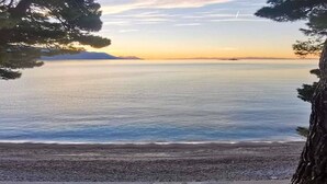 Una spiaggia con acque calme e cielo sereno.