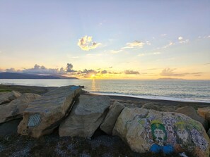Una costa rocciosa con grandi massi e una roccia decorata con colorati disegni.