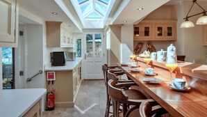 A modern kitchen with a skylight, wooden bar, and breakfast setup. - Beautiful  villa for 10 people with WIFI, terrace and pets allowed (Cawsand)