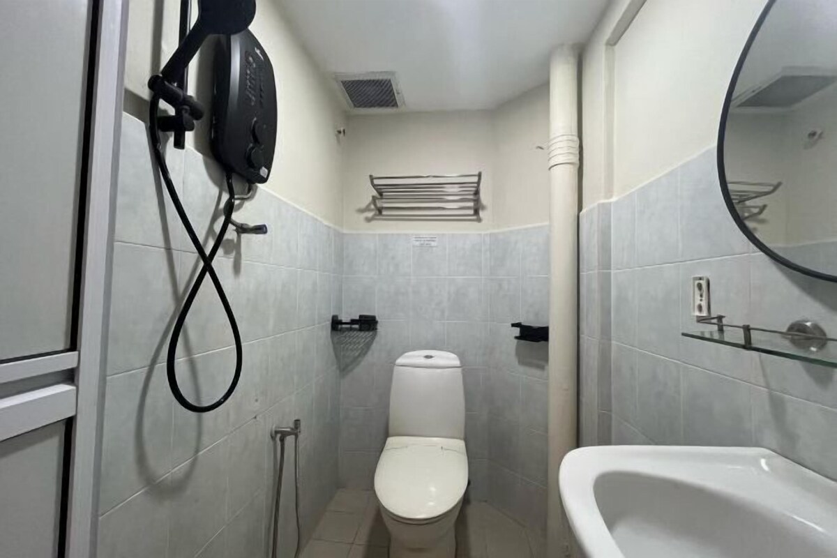 Une petite salle de bain comprenant des toilettes, une douche à parois de verre et une baignoire blanche.
