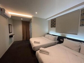 Habitación de hotel con dos camas, una ventana con cortina, aire acondicionado montado en la pared y un cuadro enmarcado.