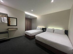 A hotel room with two beds, a mirror, a coat rack, and a small desk. - Swing and Pillows @ Malacca Mahkota Parade (Melaka)