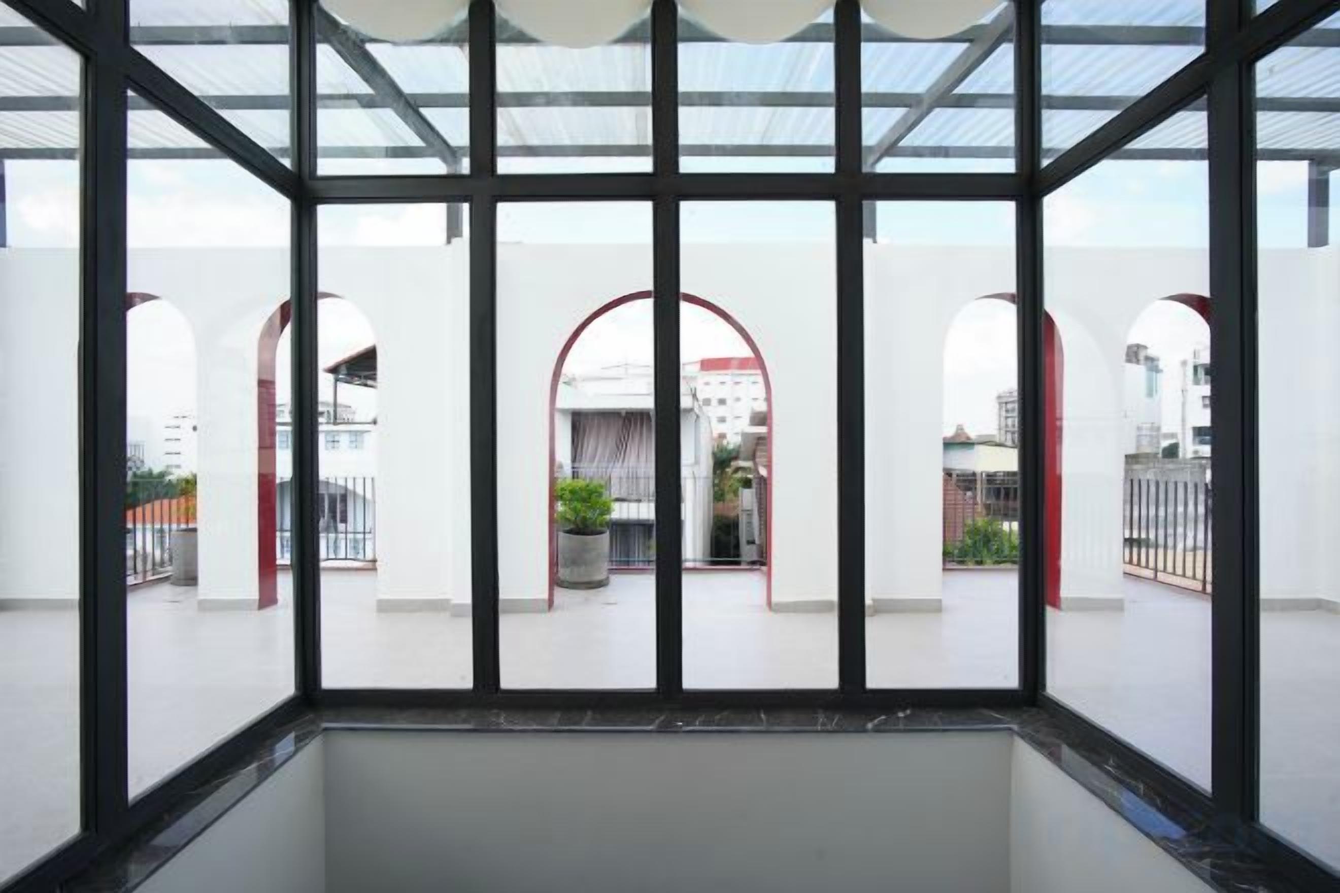 A modern interior with a glass ceiling, white walls, and arched doorways.