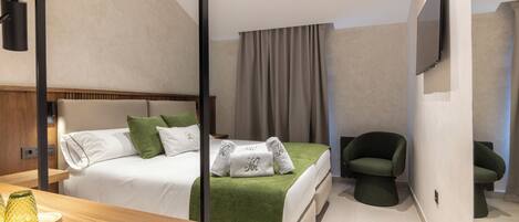 Una habitación de hotel moderna con cama, escritorio, silla y televisor.