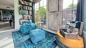 Una sala de estar acogedora con una gran estantería, un sofá azul y una alfombra.