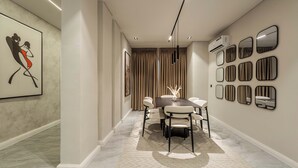 A modern dining area with a marble floor, a dark wooden table, and white chairs. There are multiple wall-mounted mirrors and an air conditioning unit. - George Residence Thompson Ave Ikoyi (Lagos)