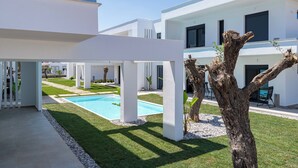 A modern building with a pool, white pillars, and a tree. - White Dream One-bedroom Apartment With Pool Access (Thasos)