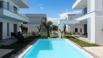 Un bâtiment moderne doté d’une piscine, d’un espace extérieur aménagé et d’un jardin bien entretenu.