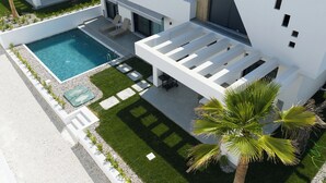 A modern building with a swimming pool, outdoor seating, and a well-maintained garden. - Emerald Three-Bedroom Villa with Private Pool and Rooftop (Kavala)