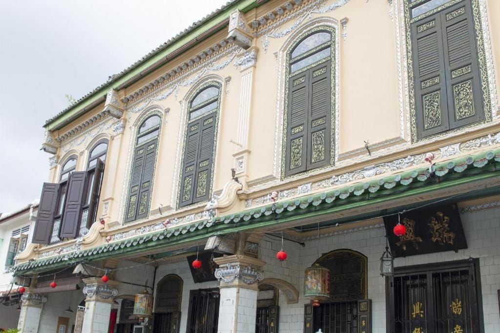Un bâtiment de style architectural traditionnel, caractérisé par des décorations élaborées et de nombreuses fenêtres dotées de volets.