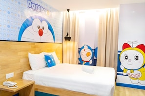 A hotel room with a bed, bedside table, and a wall with cartoon character decorations. - 96 Boutique Hotel (Melaka)
