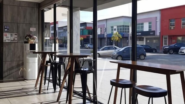 Un restaurant avec de grandes fenêtres, une terrasse et une vue sur la rue.