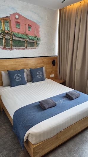 A hotel room with a bed, pillows, a headboard, a wall mural, and a window with curtains. - 96 Boutique Hotel (Melaka)