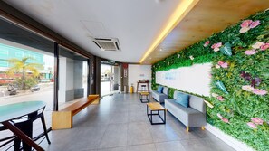 A modern hotel lobby with a green wall, seating area, and a coffee station. - 96 Boutique Hotel (Melaka)