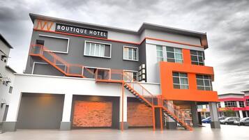 A modern boutique hotel with a prominent sign, a staircase, and a brick facade.