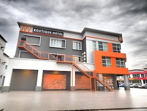 Un hôtel-boutique moderne, reconnaissable à son enseigne bien visible, à son escalier et à son mur de briques.