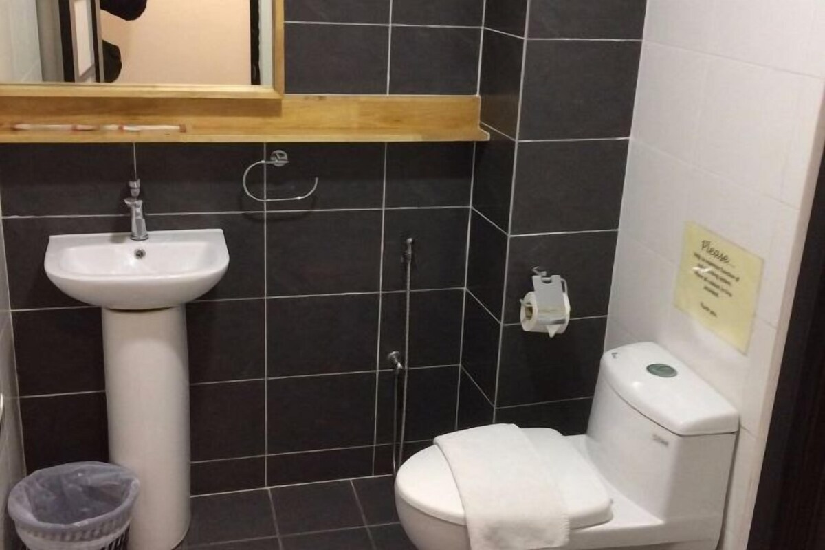 Ein Badezimmer mit einem weißen Waschbecken, einer Toilette und einem Mülleimer.