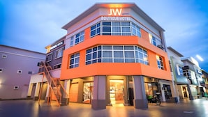 Een meerlaags boetiekhotel met een opvallend 'JW Boutique Hotel' bord.