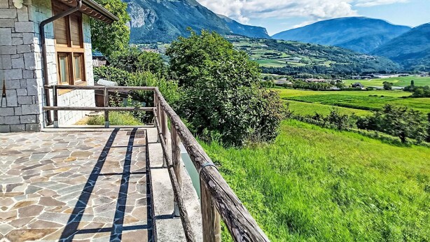 A stone building with a balcony overlooking a green valley and mountains. - Cosy apartment in villa for 5 people with WIFI, TV, terrace and panoramic view (Bleggio Superiore)