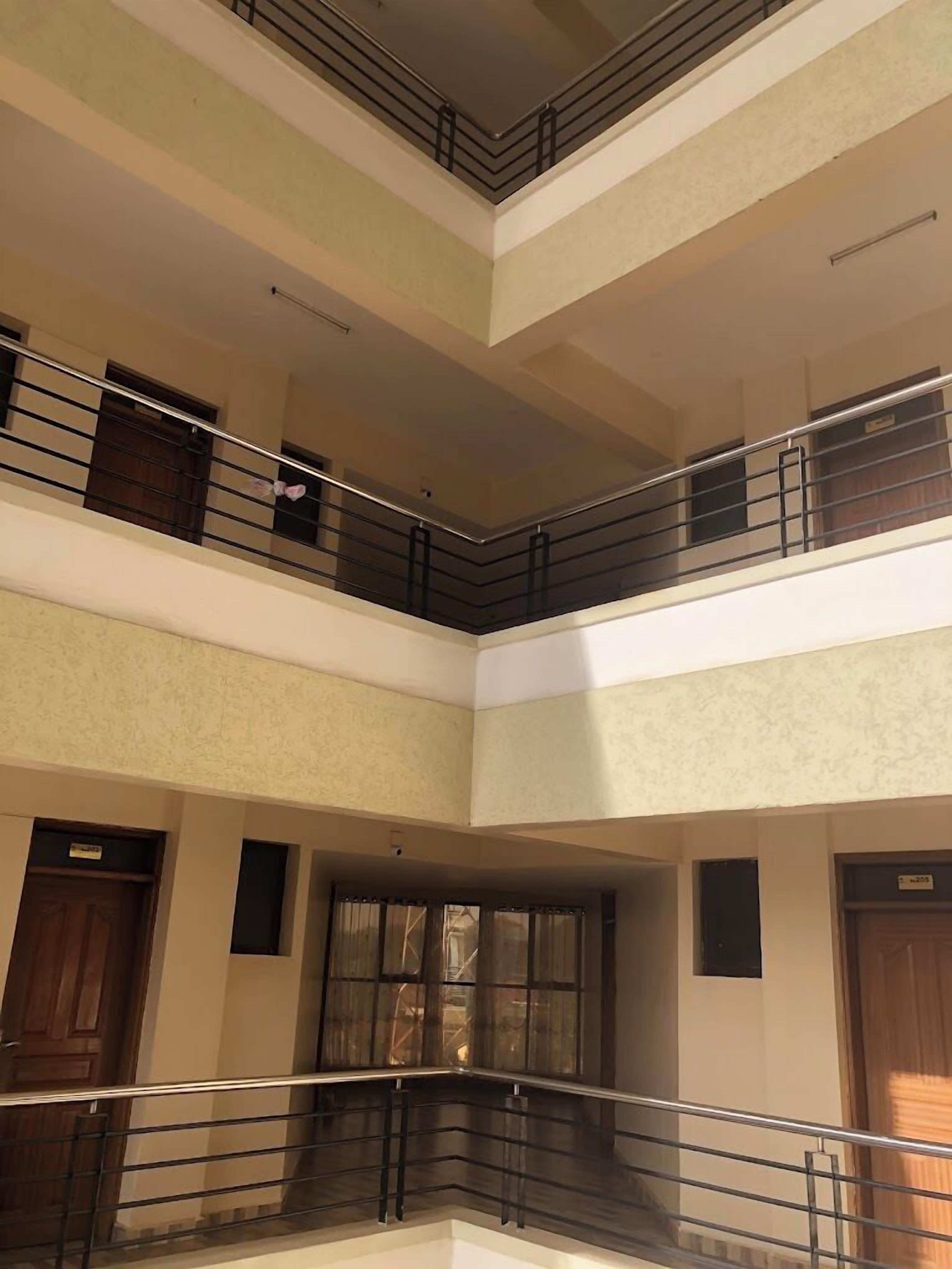 A multi-level interior with a central open space, railings, and doors on each level.