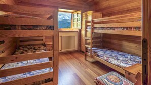 A wooden cabin with bunk beds, a window with a mountain view, and a radiator. - Beautiful private villa for 7 guests with WIFI, TV and pets allowed (Casone)
