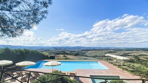 A rectangular pool with a clear blue sky and distant hills in the background. - Cosy apartment in villa for 6 guests with WIFI, pool, TV, terrace, pets allowed and panoramic view (San Giovanni D'asso)