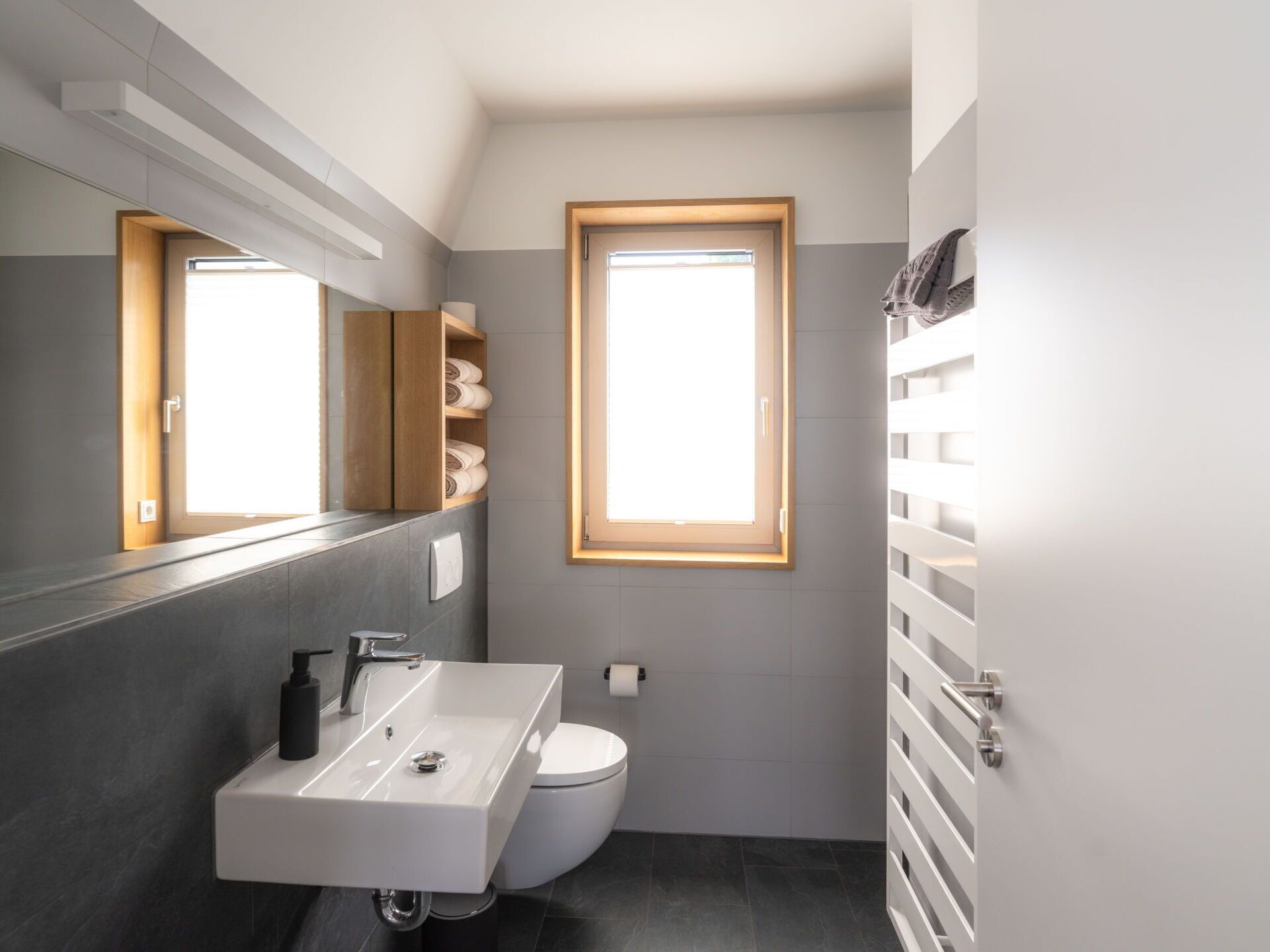 Une salle de bain moderne avec un lavabo intégré, des toilettes et une fenêtre.