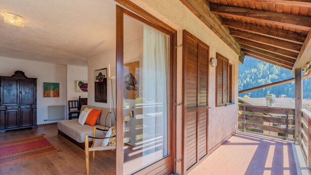 Ein Holzbalkon mit Blick auf einen Berg.