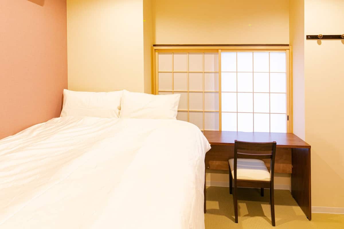 Una habitación de hotel con una cama, un escritorio y una silla.