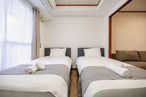 A hotel room with two single beds, a sofa, and a large window with curtains. - Sharumu Biruzu Matsuyamachi (Osaka)