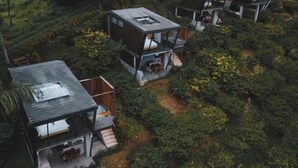 Un complexe résidentiel moderne à plusieurs étages, doté d’un toit plat et entouré d’une végétation luxuriante.