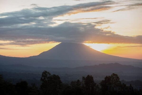 A mountain silhouette against a sunset sky.