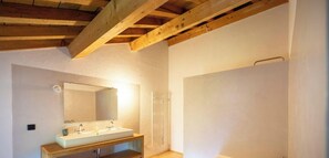 A bathroom with a wooden vanity, a large mirror, and a bathtub.