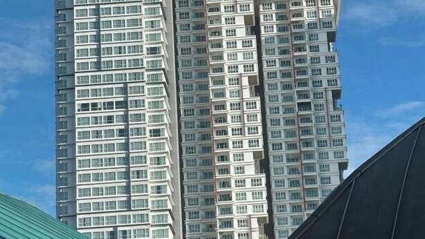 A high-rise building with multiple floors, featuring a modern architectural design with a curved facade. - Tri Tower Residence (Walk 3 minutes to Malaysia & Singapore customs) (Johor Bahru)