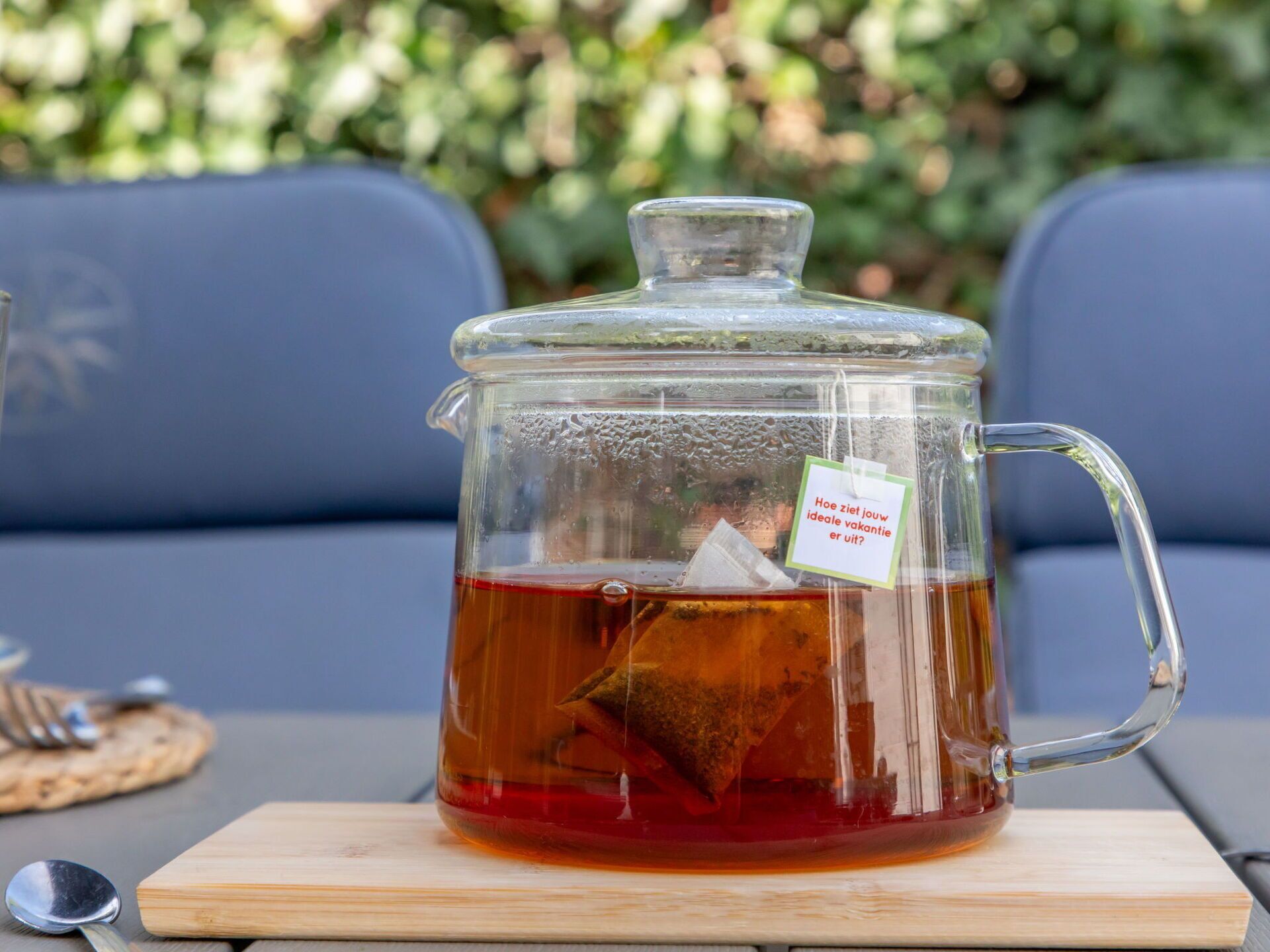 Eine Glastasse mit einem Teebeutel auf einer Holzbrett.