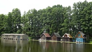 Eine Reihe von Holzhütten an einem See, umgeben von dichtem Wald.