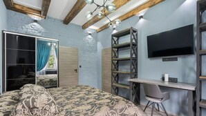 Quarto com cama, escrivaninha, televisão e guarda-roupa.